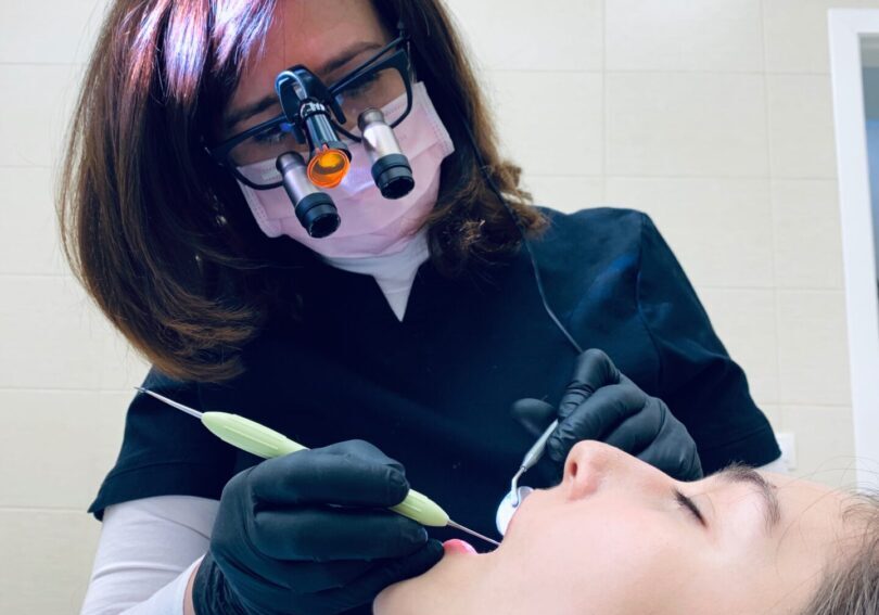 A woman is getting her teeth cleaned by an eye doctor.